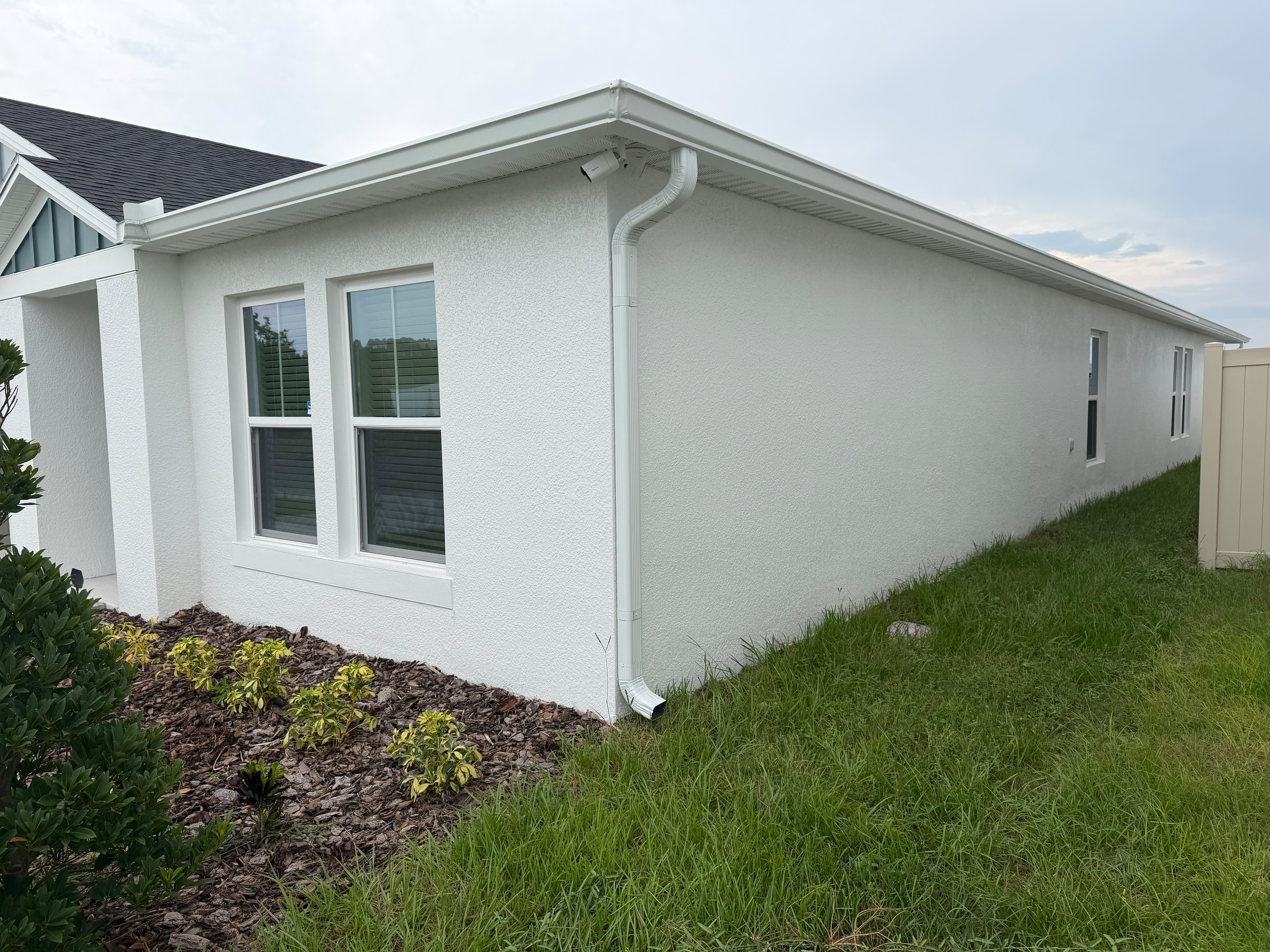 Finished white home with roofline gutter system